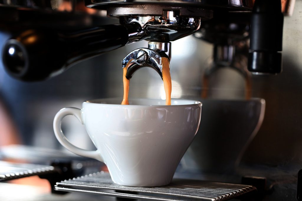 Cappuccino machine brewing into a white mug